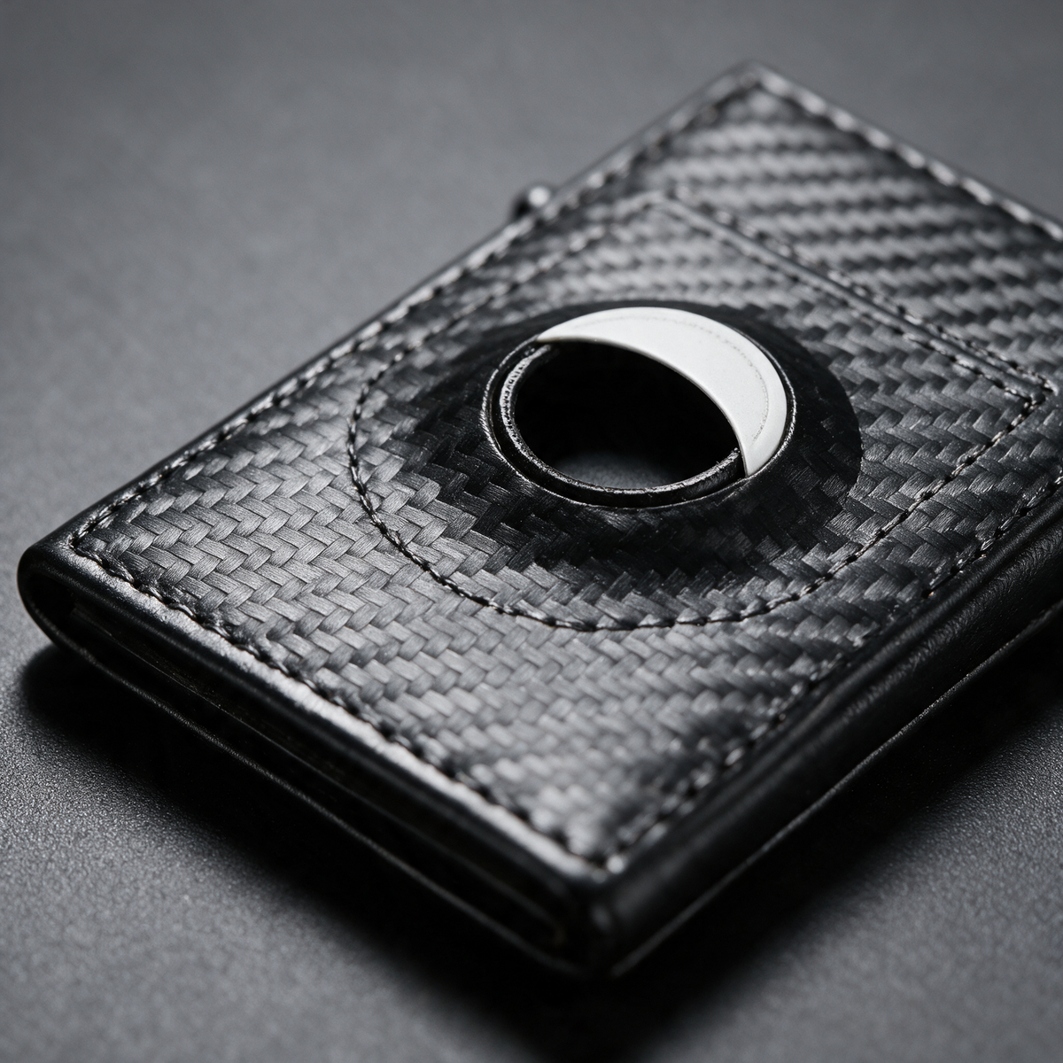 Close-up of the round AirTag recess and carbon fibre weave